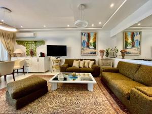 Le Chesterfield Gammarth في قمرت: غرفة معيشة بها أريكة وطاولة