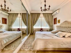 Le Chesterfield Gammarth في قمرت: غرفة نوم بها سريرين ومرآة