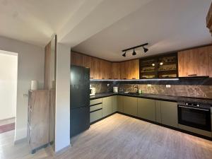a kitchen with wooden cabinets and a black refrigerator at Cheita 305 in Cheia