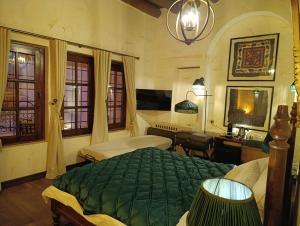een slaapkamer met een groen bed en een bureau bij Zerzembe Boutique Hotel in Sanlıurfa