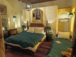 een slaapkamer met twee bedden, een bureau en een spiegel bij Zerzembe Boutique Hotel in Sanlıurfa