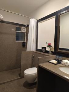 ein Badezimmer mit Toilette und Waschbecken in der Unterkunft Ello Hotels in Bangalore