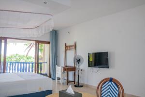 une chambre avec un lit et une télévision à écran plat dans l'établissement Diani Sands International Hotel, à Galu