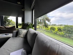 ein Wohnzimmer mit Couch und großem Fenster in der Unterkunft 沐光森野旅宿 永續旅遊 in Wujie