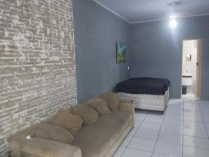 ein Wohnzimmer mit Sofa und Bett in der Unterkunft KitNet suíte Balneário shangrila in Pontal do Paraná