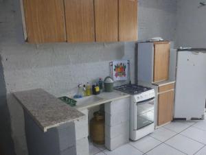 eine kleine Küche mit einem Herd und einem Kühlschrank in der Unterkunft KitNet suíte Balneário shangrila in Pontal do Paraná