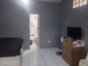 ein Schlafzimmer mit einem Bett und einem TV auf einem Schrank in der Unterkunft KitNet suíte Balneário shangrila in Pontal do Paraná