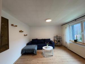 een woonkamer met een blauwe bank en een tafel bij Dom w górach Zacisze lasu in Sucha Beskidzka