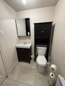 a bathroom with a toilet and a sink and a mirror at Apartement #4 avec chambre Baie Comeau in Baie-Comeau
