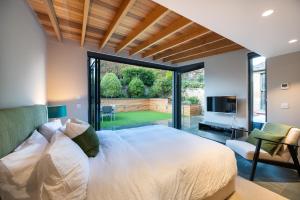 a bedroom with a large bed and a large window at Garden Rooms Edinburgh in Edinburgh