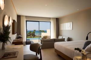 En eller flere senge i et værelse på Oros Luxury Beach Resort