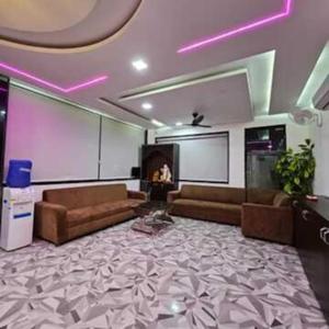 a large living room with couches and avertisement at The Inspira Hotel Haridwar in Haridwār