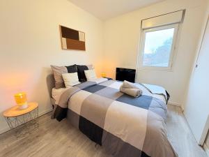 une chambre avec un grand lit et une fenêtre dans l'établissement Le Faubourg, à Pamiers