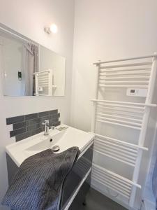 une salle de bains avec un lavabo et un miroir dans l'établissement Le Faubourg, à Pamiers