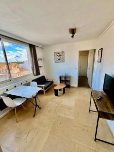 a living room with a couch and a table at Hyper Centre de Valence - Grand Studio 52 in Valence
