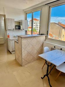 a kitchen with a counter and a table and a window at Hyper Centre de Valence - Grand Studio 52 in Valence