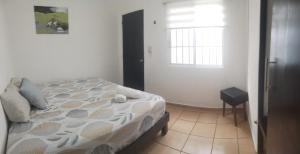 een slaapkamer met een bed en een raam bij Casa Héroes in Cancun