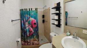 een badkamer met een douchegordijn en een wastafel bij Casa Héroes in Cancun +8 foto's