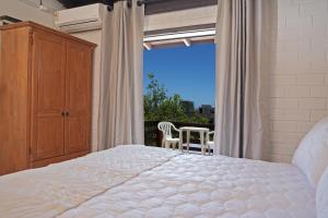 una camera da letto con un letto grande e un balcone di Pousada da Encosta a Garopaba Altre 56 foto