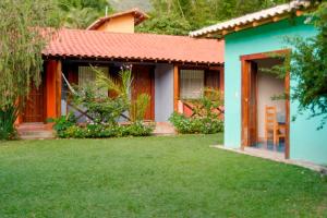 a house with a green lawn in front of it at Pousada Quintal da Serra in Serra do Cipo