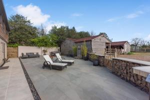 a patio with two chairs and a stone wall at Pine Ridge 1 in Bristol