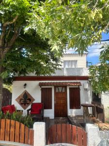 a house with red chairs in front of it at Flor de Lis Casa in La Paloma