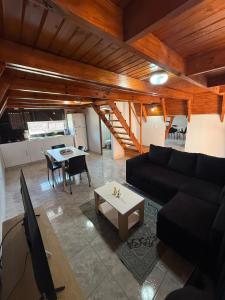 ein Wohnzimmer mit einer schwarzen Couch und einem Tisch in der Unterkunft Cabañas Alpinas M&M in Perito Moreno