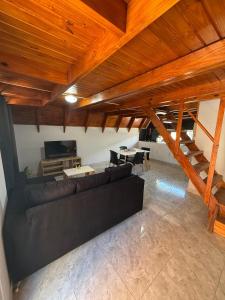 ein Wohnzimmer mit einer schwarzen Couch und einem Tisch in der Unterkunft Cabañas Alpinas M&M in Perito Moreno