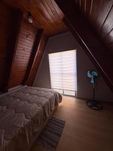 Schlafzimmer mit einem Bett und einem Fenster mit einem Ventilator in der Unterkunft Cabañas Alpinas M&M in Perito Moreno + 5 Fotos