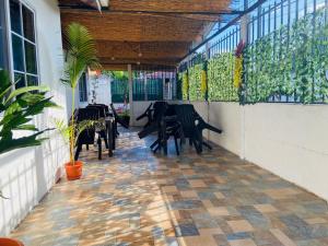 a patio with tables and chairs on a balcony at Corcovado Pura Vida Stays in Puerto Jiménez