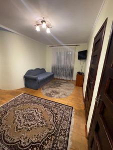 een woonkamer met een bank en een tapijt bij Karpatski Prostory in Slavske