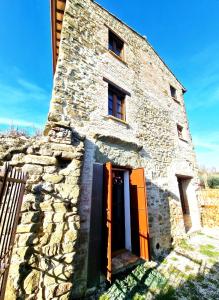 an old stone building with an orange door at Torre del Tempo in Torgiano