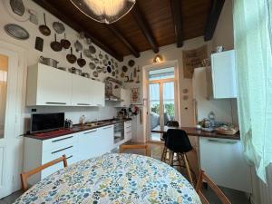 een keuken met witte kasten en een tafel bij Il Gelsomino "Meraviglioso appartamento in villa Liberty" in Gorizia
