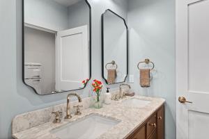 un bagno con due lavandini e un grande specchio di The Optimist Guesthouse | 2 a Camden Altre 16 foto