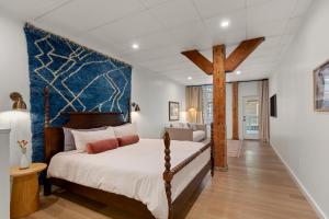 una camera da letto con un letto grande con testiera blu di The Optimist Guesthouse | 2 a Camden