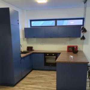una cucina con armadi blu e piano di lavoro di Central apartment Târgu Mureș a Târgu-Mureş Altre 3 foto