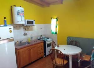 a kitchen with a white refrigerator and a table at Cosquin in Santa María