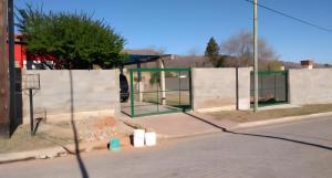 a bus stop with a green gate on a street at Cosquin in Santa María