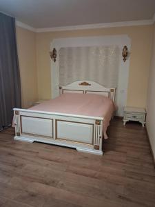 een slaapkamer met een groot bed met een roze deken bij Галичанка Еліт SPA 
