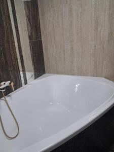 een wit bad met een slang in de badkamer bij Галичанка Еліт SPA 