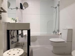 un bagno bianco con un water e un lavandino di Smartmonki Sinagoga Entre la Catedral y Zocodover a Toledo Altre 133 foto