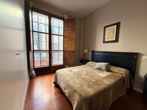 una camera da letto con un letto e due finestre di Smartmonki Sinagoga Entre la Catedral y Zocodover a Toledo