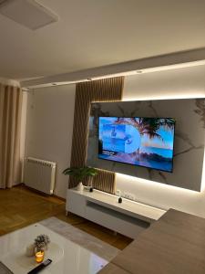een woonkamer met een grote flatscreen-tv aan de muur bij Cetral032 in Čačak