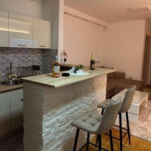 a kitchen with a brick counter and two chairs at Cetral032 in Čačak