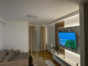 a living room with a large flat screen tv on a wall at Cetral032 in Čačak