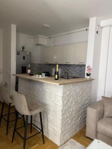 a kitchen and living room with a counter and chairs at Cetral032 in Čačak +14 photos