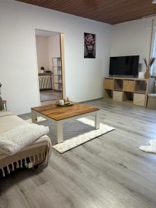 een woonkamer met een tafel en een tv bij MelsHome Apartment mit 2 Schlafzimmer in Geislingen an der Steige