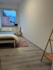 een witte kamer met een bed en een raam bij MelsHome Apartment mit 2 Schlafzimmer in Geislingen an der Steige