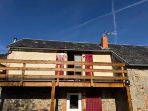 a building with red shuttered windows and a roof at Maison typique Auvergne in Montel-de-Gelat +3 photos