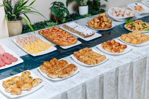 een tafel met veel verschillende soorten voedsel op borden bij Elite art hotel in Tasjkent
